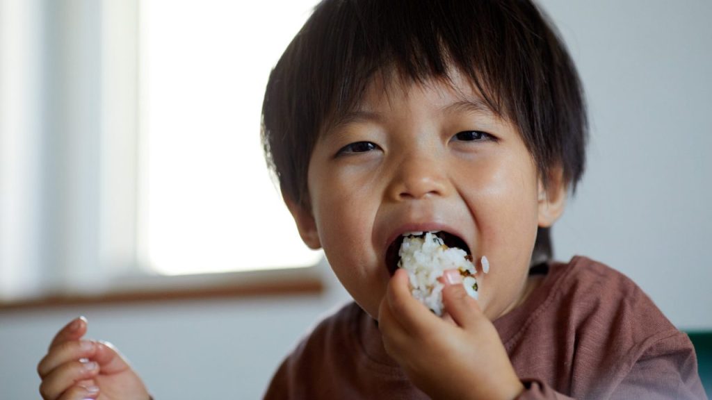 おにぎりを頬張る子供
