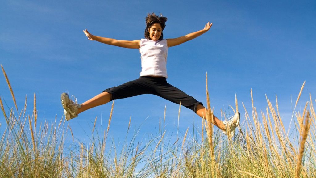手と足を開いてジャンプする女性