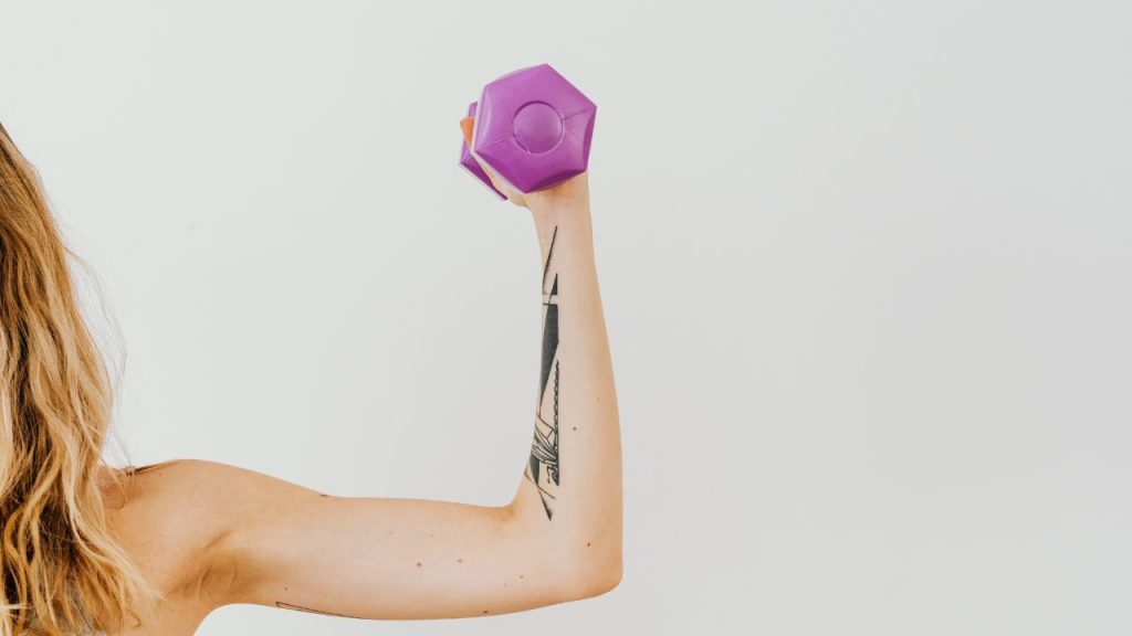 ダンベルを持って上腕二頭筋を見せている女性