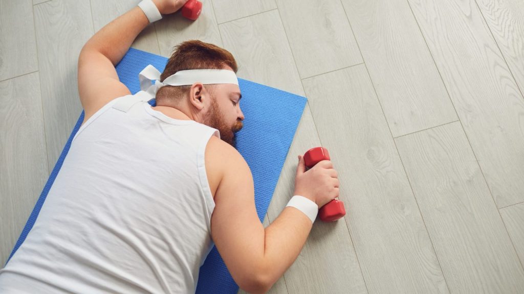 ダンベルを持って疲れている人