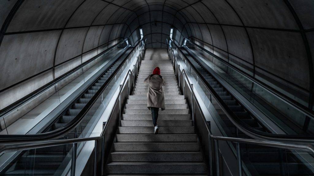 エスカレーターではなく階段で登る女性