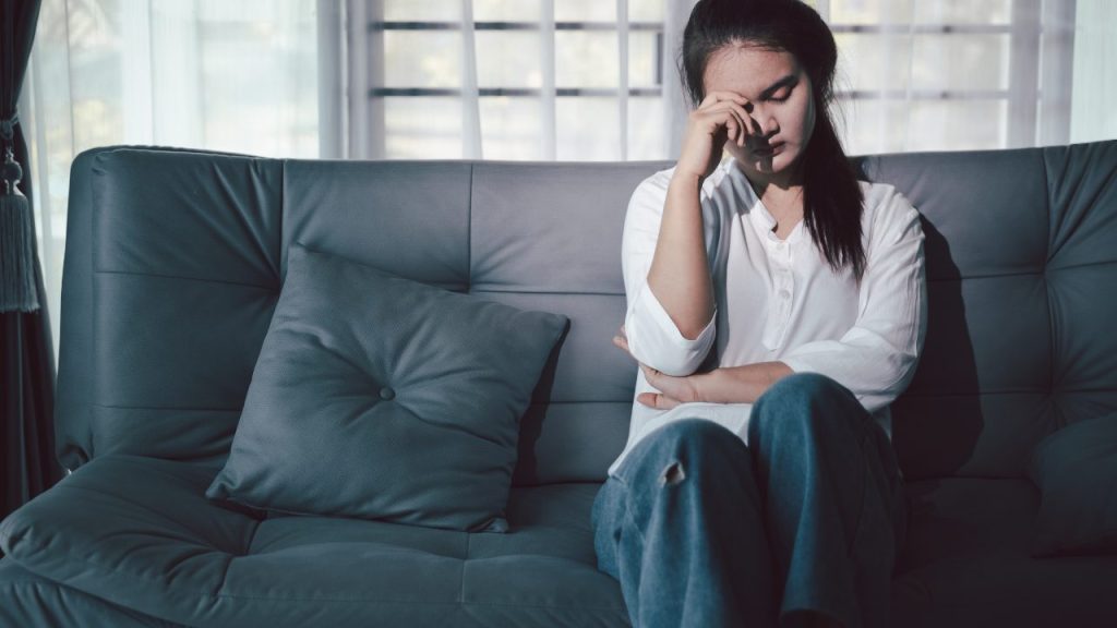 ソファーで悩む女性